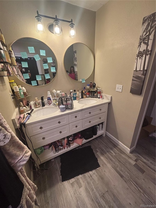 206 Lyell St, Monte Vista, CO 81144 - full bath with wood finished floors, a textured wall, and double vanity