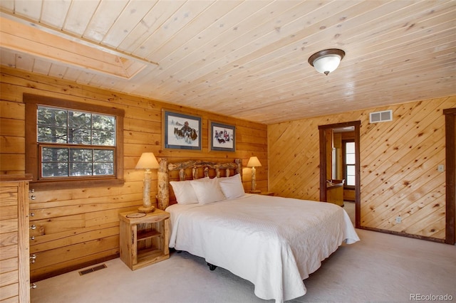 carpeted bedroom with wooden ceiling and wood walls