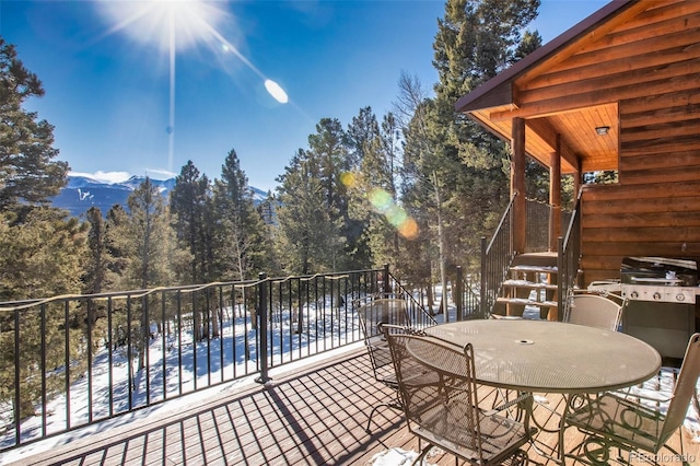 snow covered patio with a covered pool, area for grilling, and a mountain view