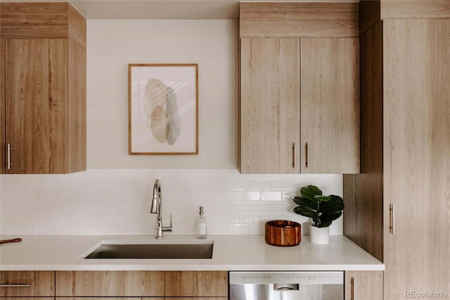 kitchen featuring stainless steel dishwasher, light brown cabinets, tasteful backsplash, and sink