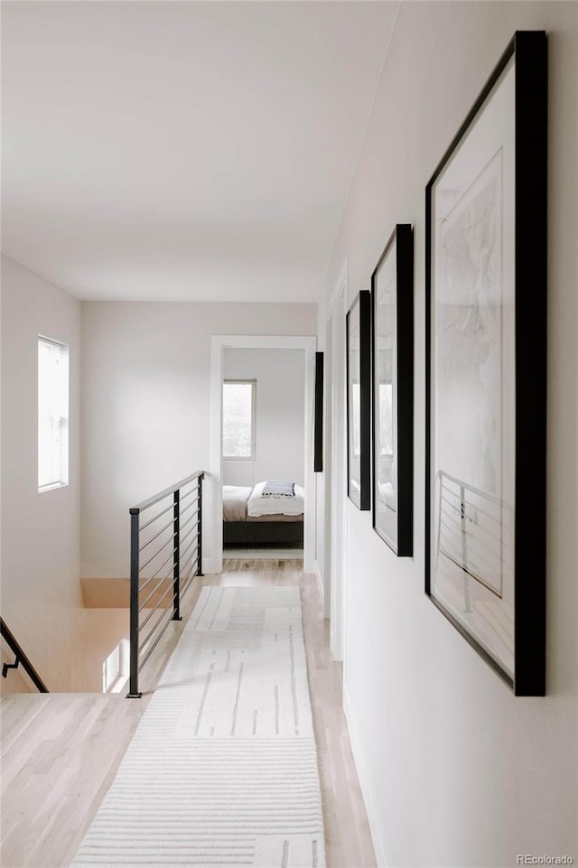 hall with light wood-type flooring and a wealth of natural light