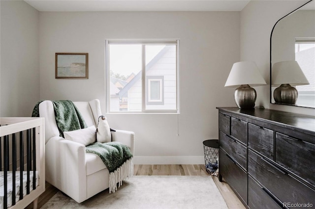 bedroom featuring light wood-type flooring and a crib