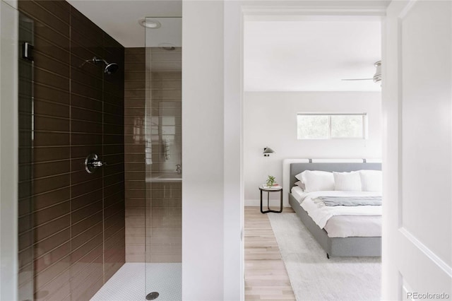 bathroom with walk in shower, hardwood / wood-style flooring, and ceiling fan