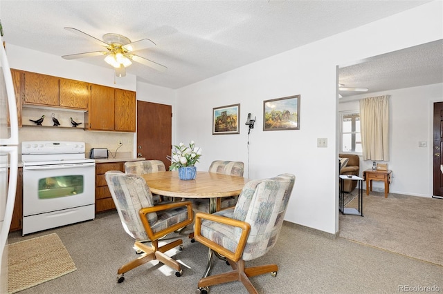 kitchen featuring brown cabinets, white range with electric cooktop, light colored carpet, light countertops, and a textured ceiling