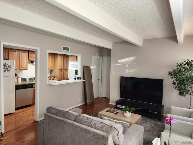 living room featuring dark wood-style flooring, baseboards, beam ceiling, visible vents, and a textured ceiling