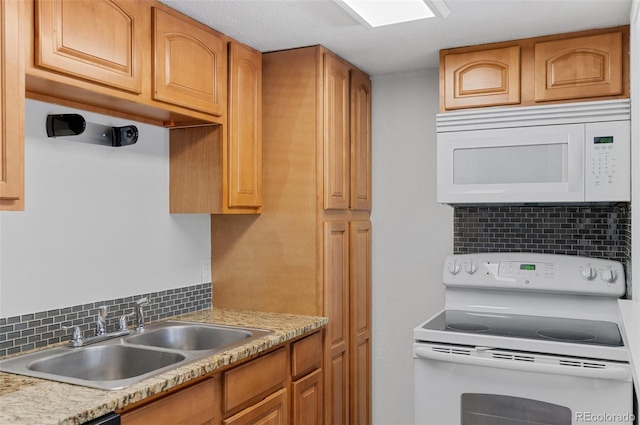 kitchen featuring white appliances, tasteful backsplash, light countertops, and a sink