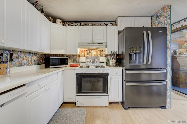 41215 Alta Vista Rd, Ramah, CO 80832 - kitchen with light countertops, white cabinets, under cabinet range hood, light wood-style floors, and stainless steel appliances