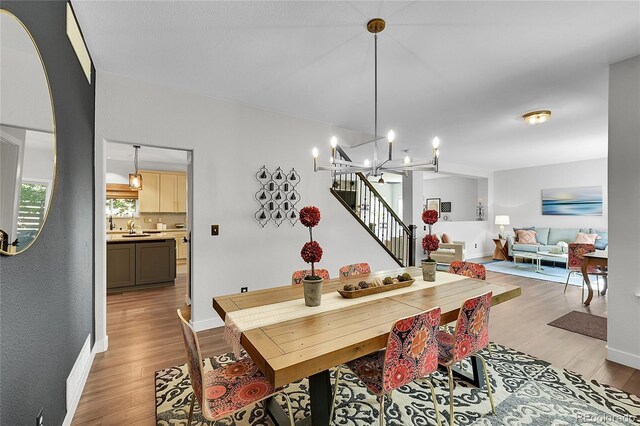 215 Mcafee Cir, Erie, CO 80516 - dining area with light wood-style flooring, stairway, and a chandelier