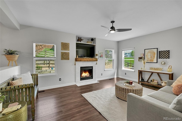 215 Mcafee Cir, Erie, CO 80516 - living area featuring a glass covered fireplace, dark wood-style flooring, and a ceiling fan