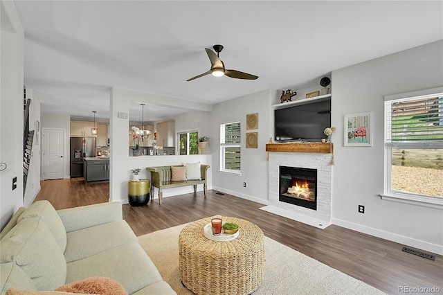 215 Mcafee Cir, Erie, CO 80516 - living room featuring healthy amount of natural light, dark wood-style flooring, ceiling fan, and a fireplace