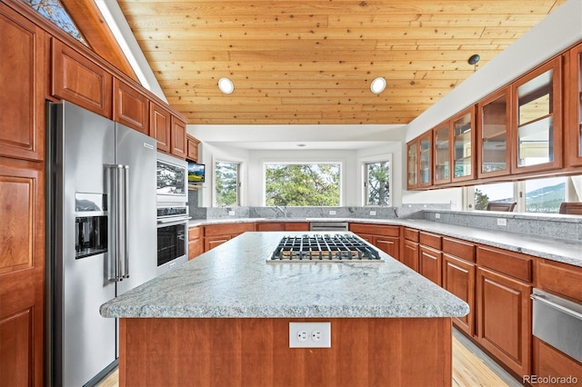 kitchen featuring a warming drawer, a kitchen island, stainless steel appliances, wooden ceiling, and brown cabinetry