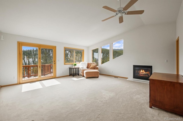 unfurnished room featuring a glass covered fireplace, vaulted ceiling, baseboards, and carpet floors