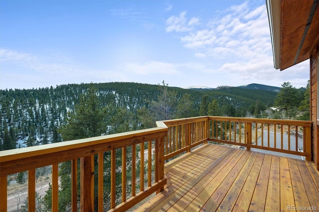 wooden terrace with a view of trees and a mountain view