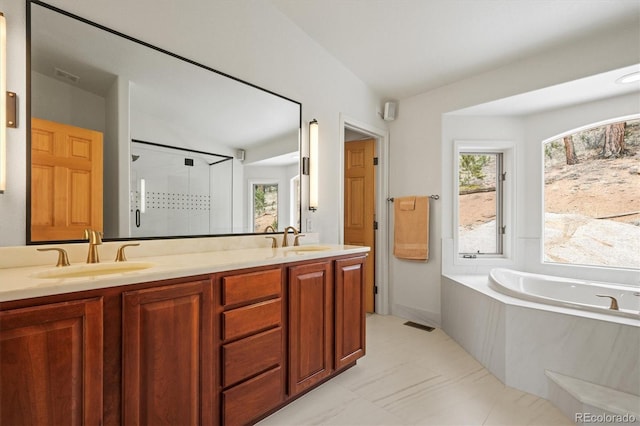 bathroom with double vanity, a bath, a shower stall, and a sink