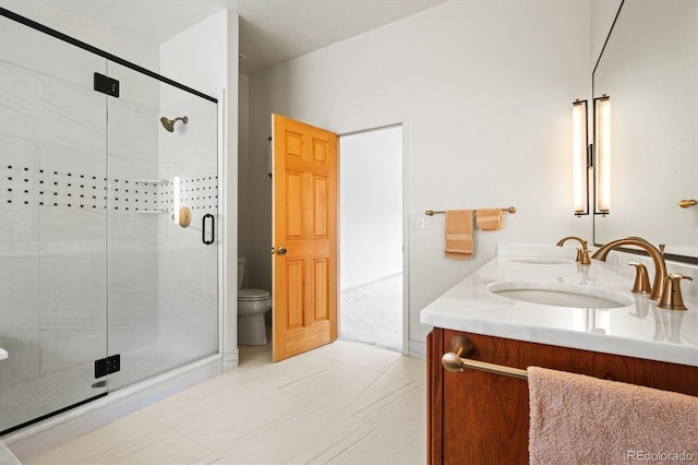 bathroom with a shower stall, toilet, double vanity, and a sink