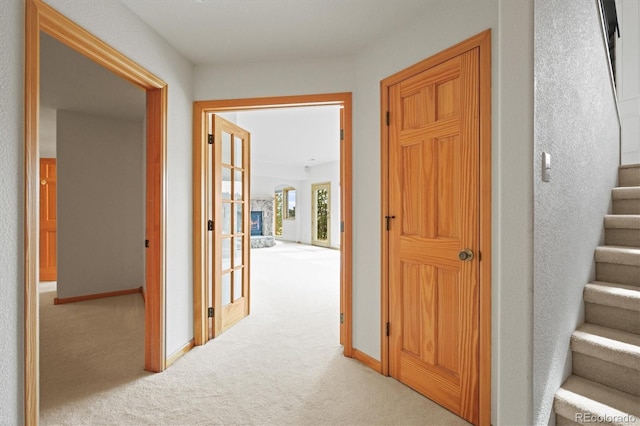 hallway with baseboards, carpet floors, and stairs