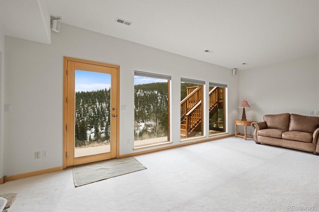 unfurnished living room with visible vents, baseboards, and carpet