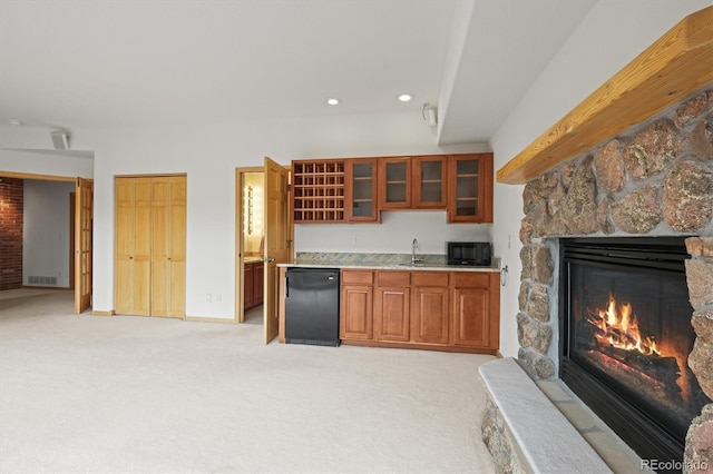 kitchen with visible vents, a stone fireplace, black microwave, light carpet, and fridge