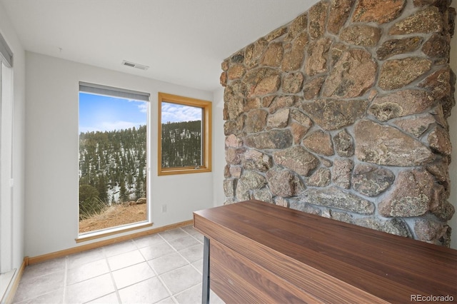 doorway to outside featuring tile patterned floors, baseboards, and visible vents