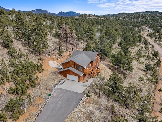 drone / aerial view featuring a mountain view and a wooded view