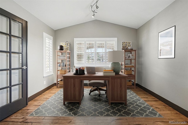 19423 W 52nd Dr, Golden, CO 80403 - office featuring track lighting, baseboards, lofted ceiling, and wood finished floors