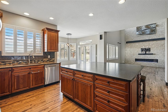 19423 W 52nd Dr, Golden, CO 80403 - kitchen featuring dishwasher, light wood-style flooring, a sink, and dark countertops