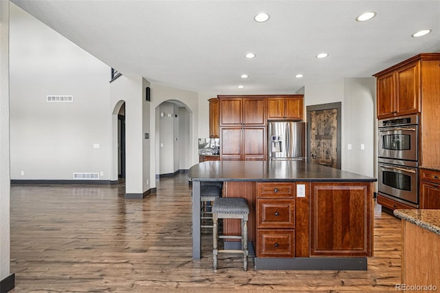 19423 W 52nd Dr, Golden, CO 80403 - kitchen with arched walkways, visible vents, stainless steel appliances, and a kitchen island