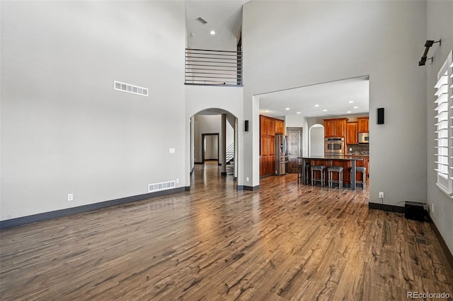 19423 W 52nd Dr, Golden, CO 80403 - living room featuring dark wood-style flooring, arched walkways, baseboards, and visible vents