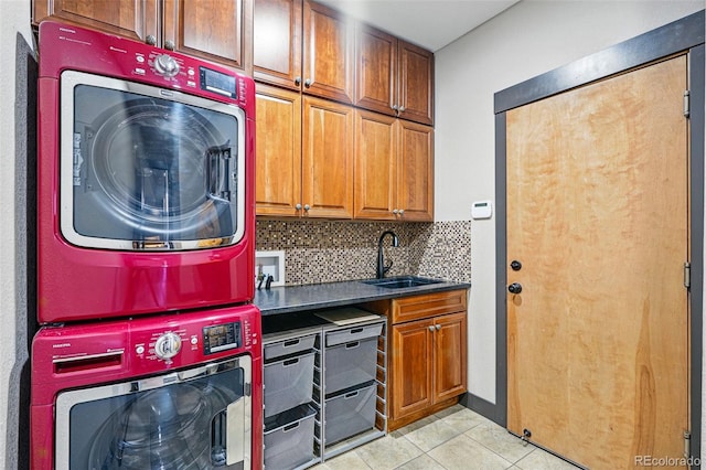 19423 W 52nd Dr, Golden, CO 80403 - kitchen with stacked washer and dryer, light tile patterned flooring, a sink, tasteful backsplash, and brown cabinets