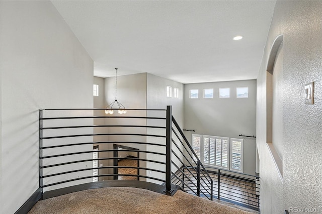 19423 W 52nd Dr, Golden, CO 80403 - stairs with a high ceiling, a textured wall, a notable chandelier, and a healthy amount of sunlight