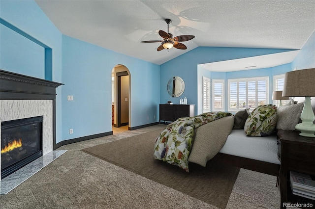 19423 W 52nd Dr, Golden, CO 80403 - carpeted bedroom featuring a high end fireplace, arched walkways, baseboards, and lofted ceiling
