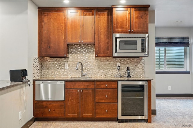 19423 W 52nd Dr, Golden, CO 80403 - kitchen featuring light stone counters, a sink, tasteful backsplash, appliances with stainless steel finishes, and beverage cooler
