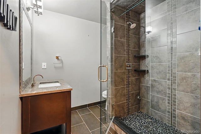 19423 W 52nd Dr, Golden, CO 80403 - full bathroom featuring a stall shower, tile patterned floors, toilet, vanity, and baseboards