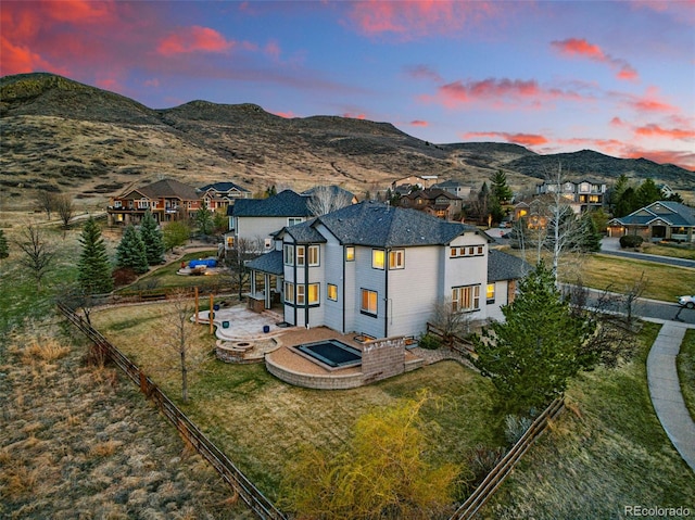 19423 W 52nd Dr, Golden, CO 80403 - exterior space with a lawn, a mountain view, a fenced backyard, and a fire pit