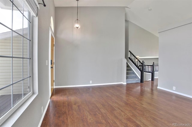 245 Homestead Way, Brighton, CO 80601 - empty room featuring high vaulted ceiling, stairs, and wood finished floors