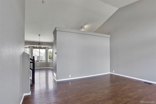 245 Homestead Way, Brighton, CO 80601 - empty room with dark wood-style flooring, vaulted ceiling, and a chandelier