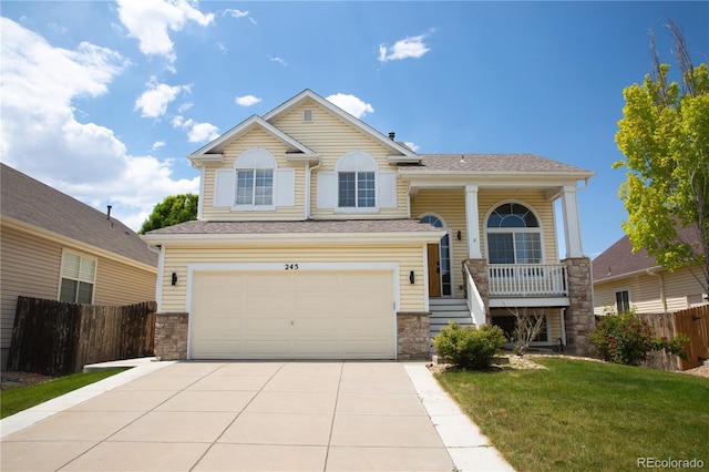 245 Homestead Way, Brighton, CO 80601 - view of front of house with stone siding, a garage, covered porch, and concrete driveway