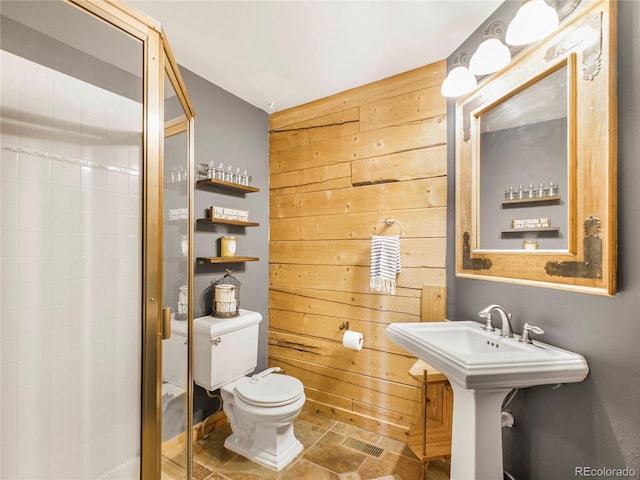 24 Pine Valley Rd, Evergreen, CO 80439 - full bathroom with visible vents, wood walls, toilet, a shower stall, and a sink