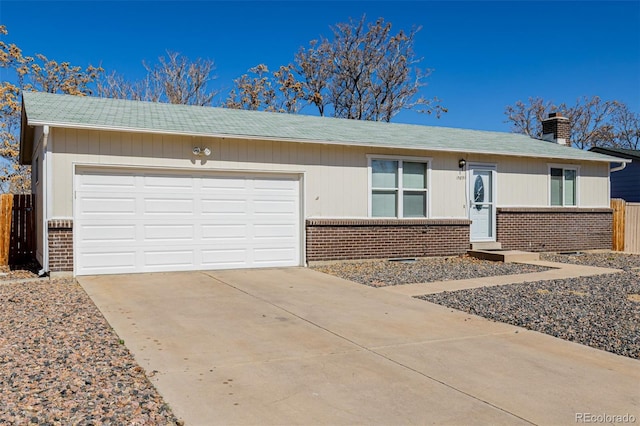 ranch-style home with fence, driveway, an attached garage, a chimney, and brick siding