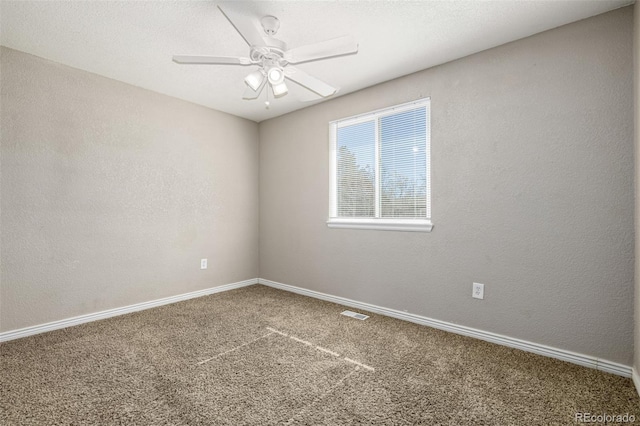 unfurnished room featuring a textured wall, baseboards, carpet floors, and ceiling fan