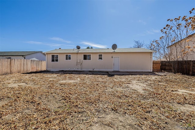 rear view of house featuring a fenced backyard