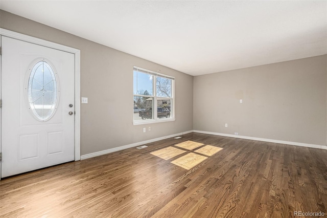 foyer featuring visible vents, baseboards, and wood finished floors