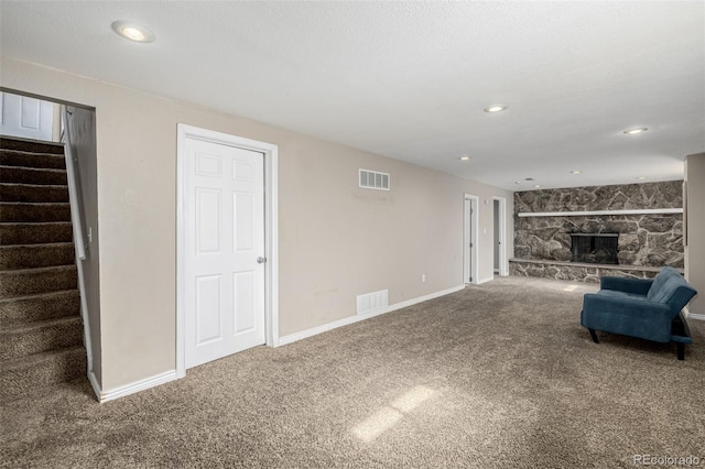 unfurnished living room with visible vents, carpet flooring, a fireplace, and stairs