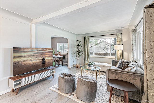 living room featuring beamed ceiling and plenty of natural light