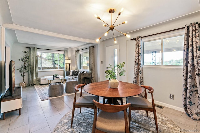 tiled dining space featuring an inviting chandelier