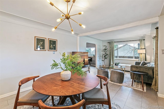 tiled dining room with a chandelier