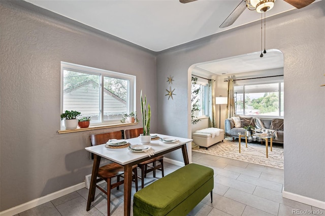 dining space with tile patterned floors and ceiling fan