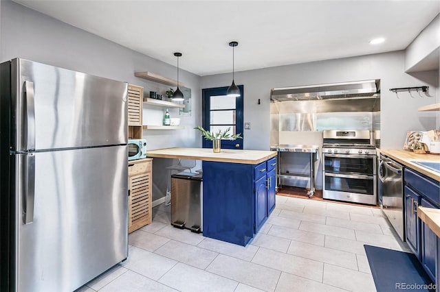 kitchen with wooden counters, a center island, stainless steel appliances, blue cabinetry, and wall chimney range hood