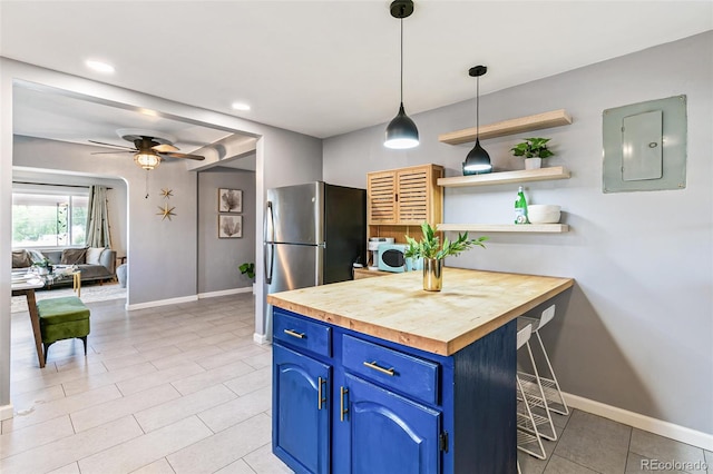 kitchen with washer / clothes dryer, blue cabinets, butcher block counters, a breakfast bar area, and electric panel