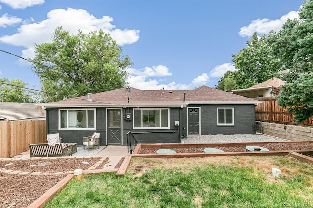 rear view of property with a lawn and a patio